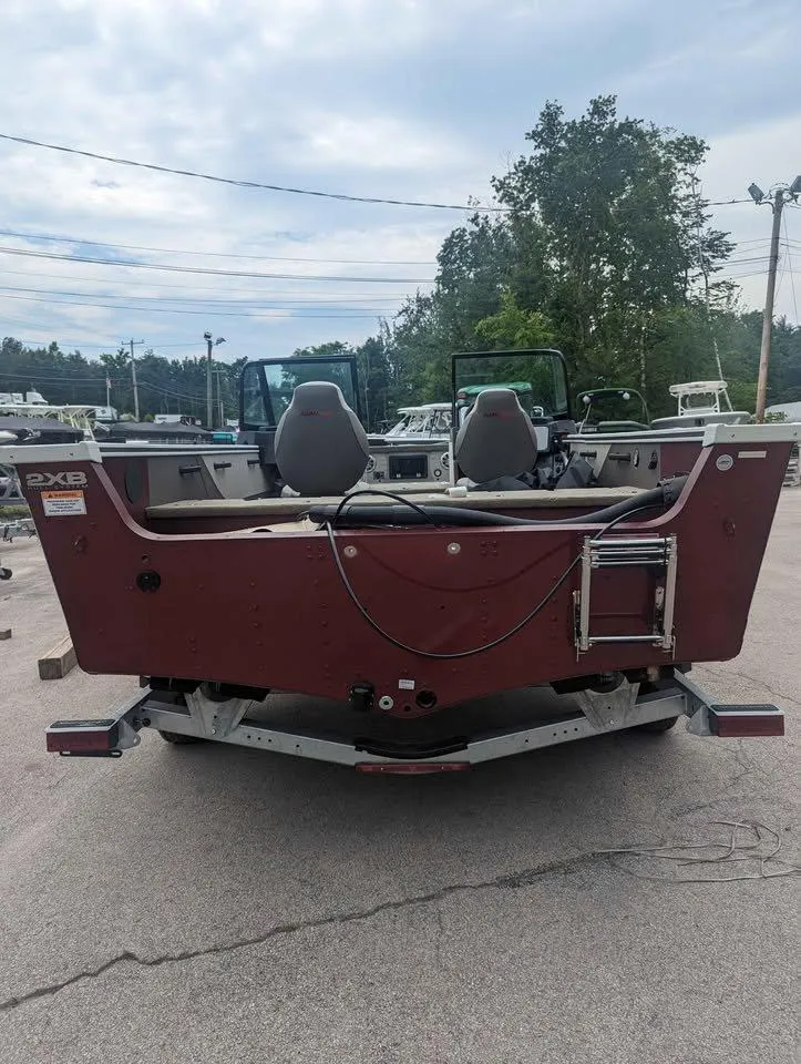 Slide: The Image of 2024 Alumacraft Trophy 185 boat, rear view, parked outdoors. - 4