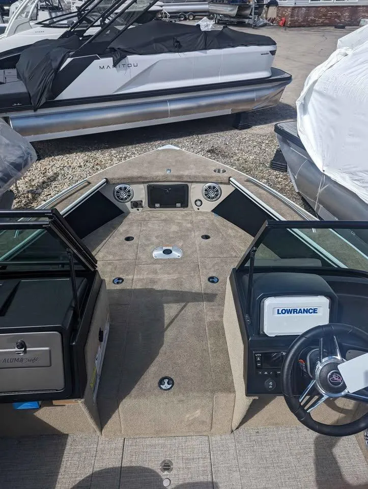 Slide: The Image of 2024 Alumacraft Trophy 185 boat interior with Lowrance electronics, docked outdoors. - 9