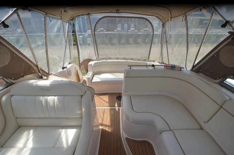 Slide: The Image of 2005 Rinker Fiesta Vee 300 EC boat interior with white seating and wood flooring. - 11