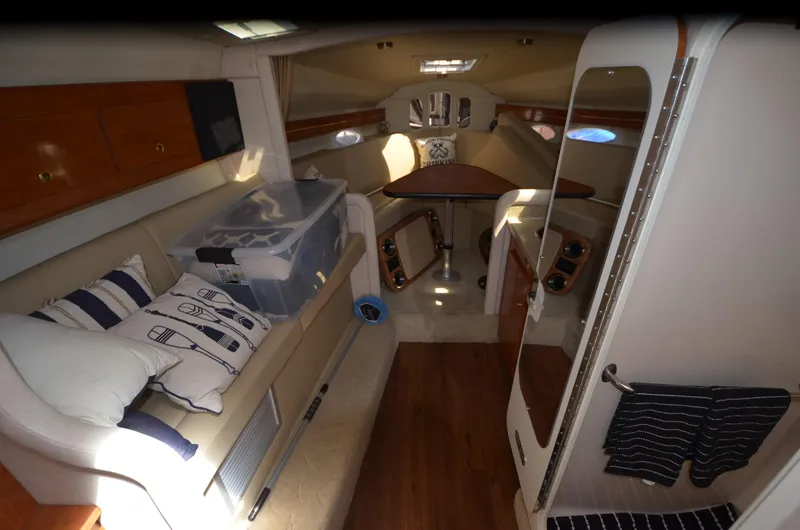Slide: The Image of 2005 Rinker Fiesta Vee 300 EC cabin interior with seating, table, and storage. - 13