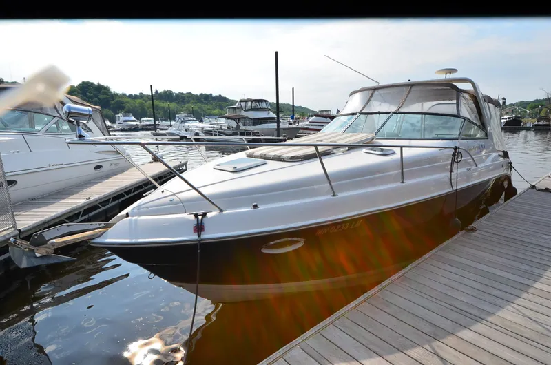 Slide: The Image of 2005 Rinker Fiesta Vee 300 EC docked at a marina, surrounded by other boats. - 2