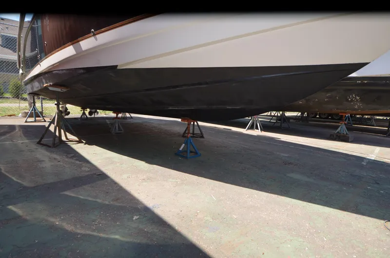 Slide: The Image of 2005 Rinker Fiesta Vee 300 EC boat hull on stands in a storage yard. - 22