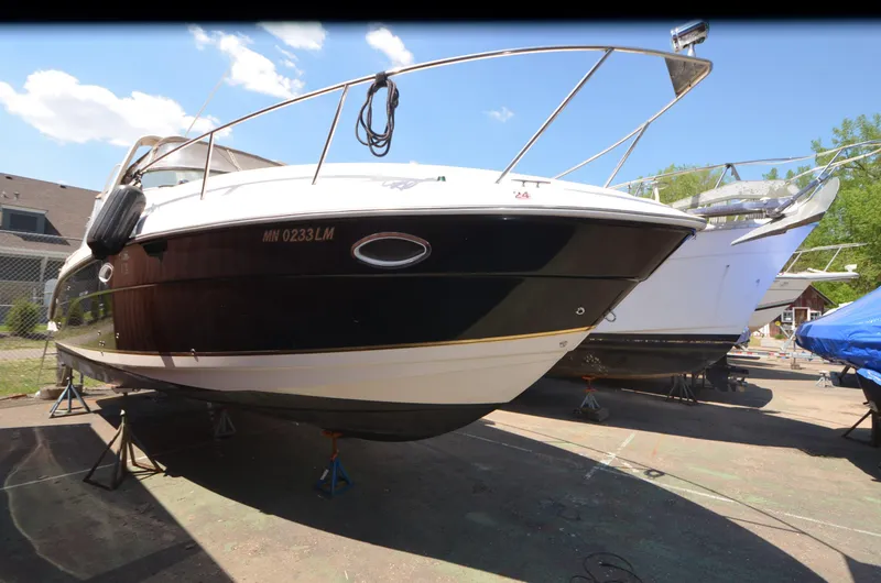 Slide: The Image of 2005 Rinker Fiesta Vee 300 EC boat on dry dock, black and white hull. - 3