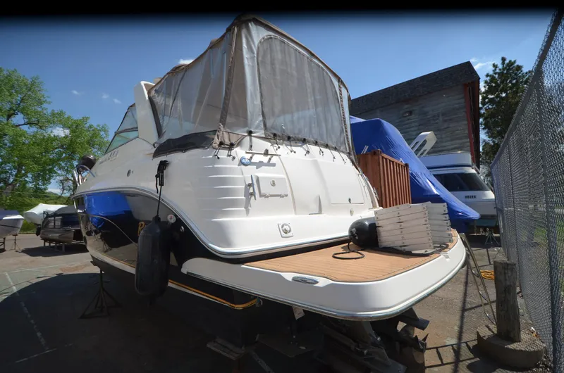 Slide: The Image of 2005 Rinker Fiesta Vee 300 EC boat docked, featuring a covered deck and sleek design. - 5