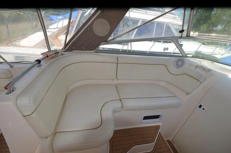 Slide: The Image of 2005 Rinker Fiesta Vee 300 EC boat interior with white seating and wood flooring. - 8