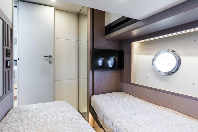 Slide: The Image of Interior of 2026 Absolute Navetta 53 yacht cabin with twin beds and porthole. - 36