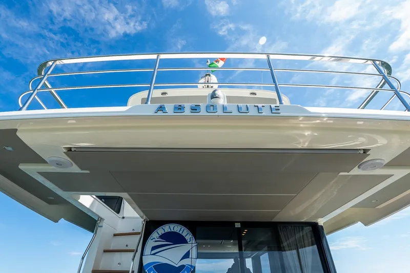 Slide: The Image of 2026 Absolute Navetta 53 yacht, rear view with blue sky background. - 40