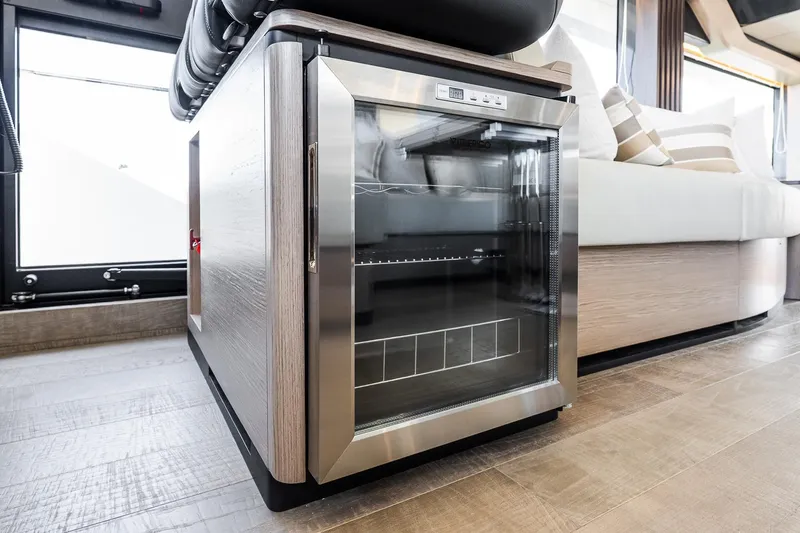 Slide: The Image of Modern interior of Absolute Navetta 53 yacht, featuring a sleek glass-door refrigerator, 2026 model. - 23