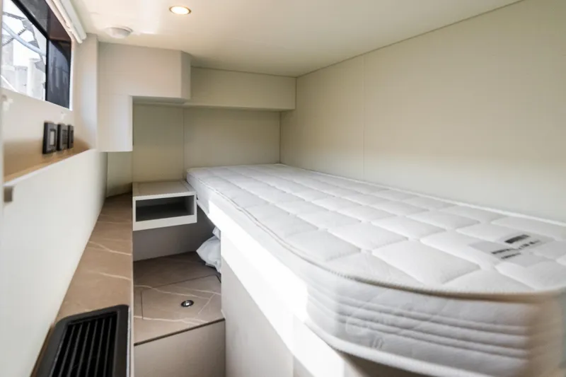 Slide: The Image of Compact cabin interior of 2026 Absolute Navetta 53 yacht with single bed and window. - 38