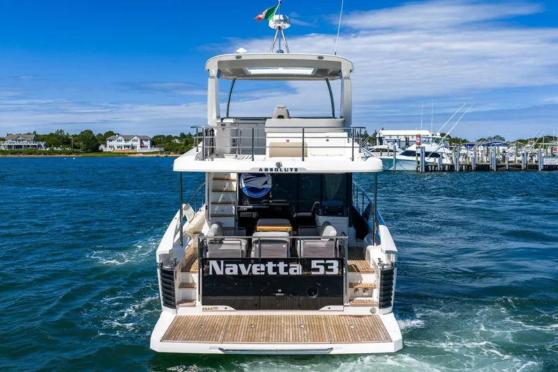 Slide: The Image of Rear view of 2026 Absolute Navetta 53 yacht cruising in a scenic marina. - 6