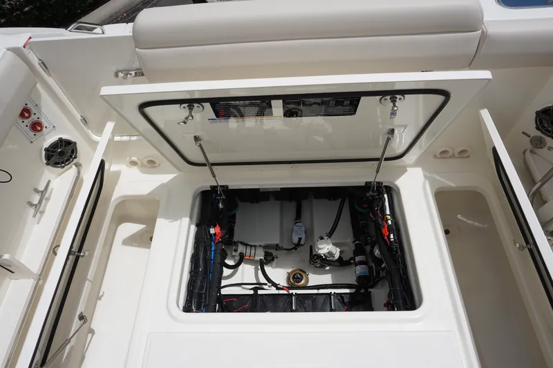 Slide: The Image of 2025 Boston Whaler 280 Outrage boat storage compartment with open hatch and visible wiring. - 11