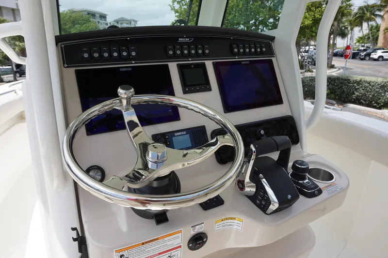 Slide: The Image of 2025 Boston Whaler 280 Outrage helm with advanced navigation controls and sleek steering wheel. - 21