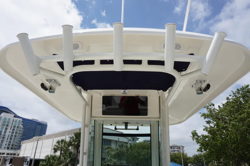 Slide: The Image of 2025 Boston Whaler 280 Outrage boat top view with rod holders and cityscape background. - 22