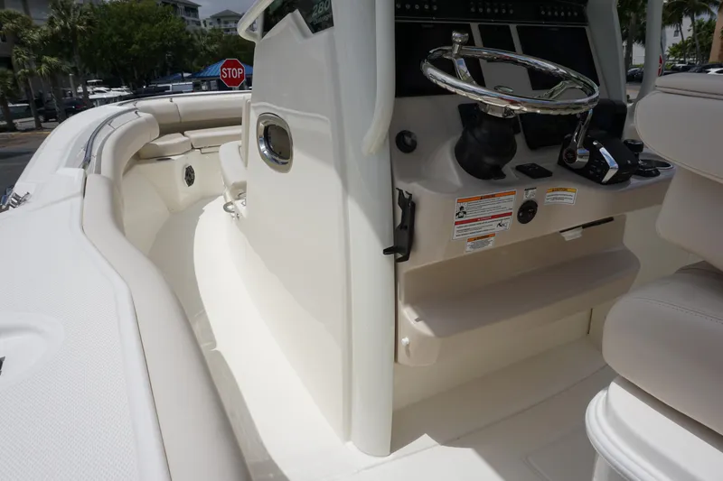 Slide: The Image of 2025 Boston Whaler 280 Outrage boat interior with steering wheel and seating area. - 23