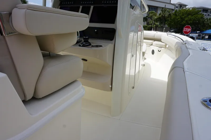 Slide: The Image of 2025 Boston Whaler 280 Outrage boat interior with beige seating and control panel. - 24