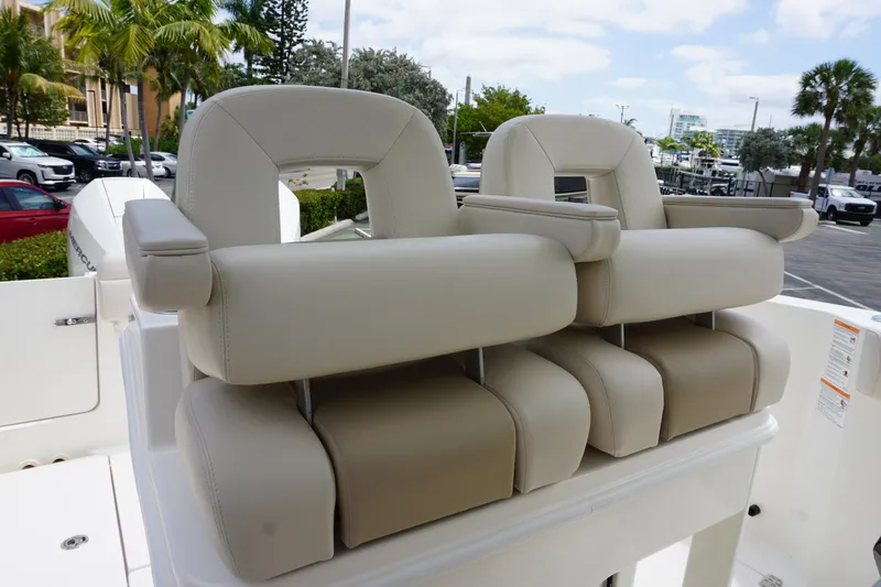Slide: The Image of 2025 Boston Whaler 280 Outrage boat seats, featuring plush beige upholstery and armrests. - 25