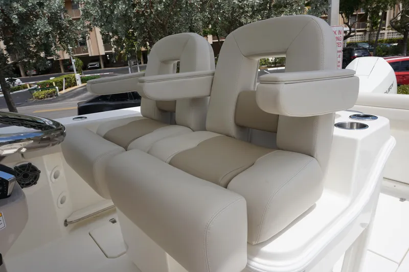 Slide: The Image of 2025 Boston Whaler 280 Outrage boat seats, featuring plush beige upholstery and armrests. - 28