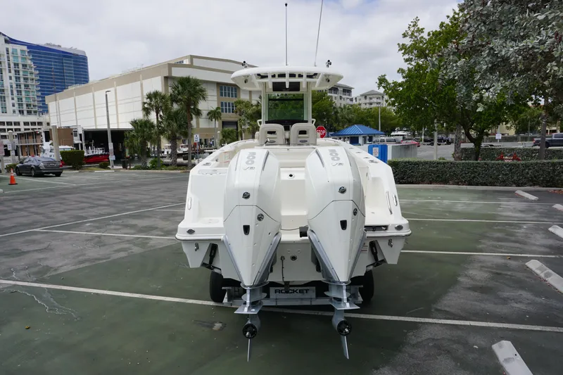 Slide: The Image of 2025 Boston Whaler 280 Outrage boat with dual engines in a parking lot. - 3