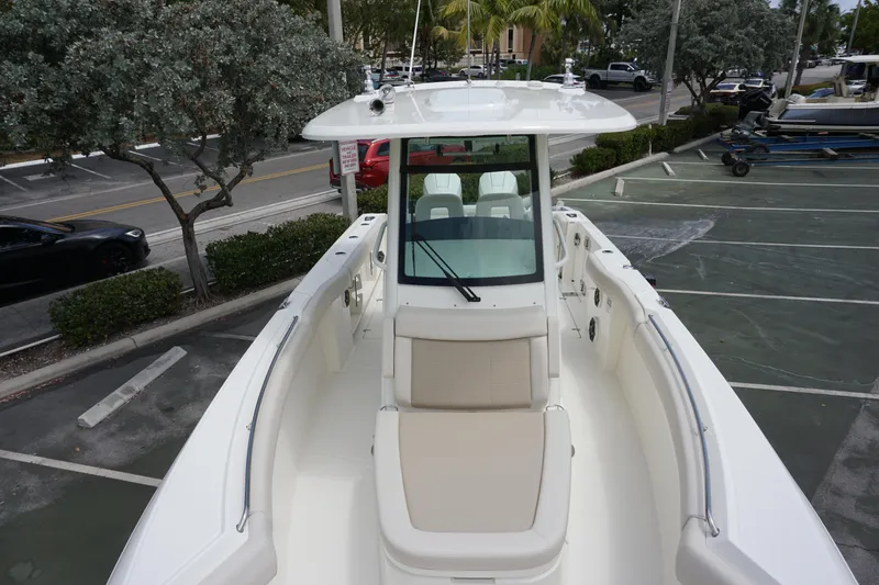 Slide: The Image of 2025 Boston Whaler 280 Outrage boat, white exterior, parked in a marina. - 33