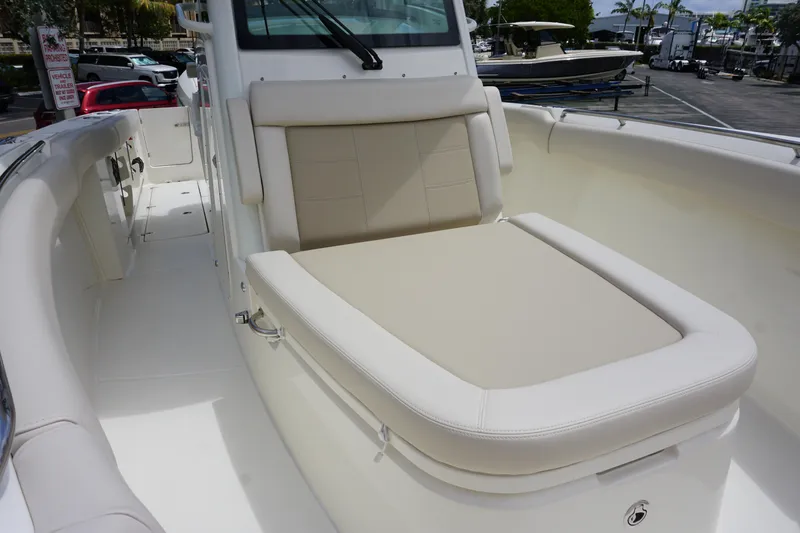 Slide: The Image of 2025 Boston Whaler 280 Outrage boat with beige seating in a marina setting. - 35