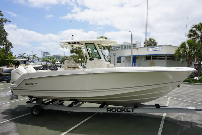 Slide: The Image of 2025 Boston Whaler 280 Outrage boat on trailer in marina parking lot. - 4