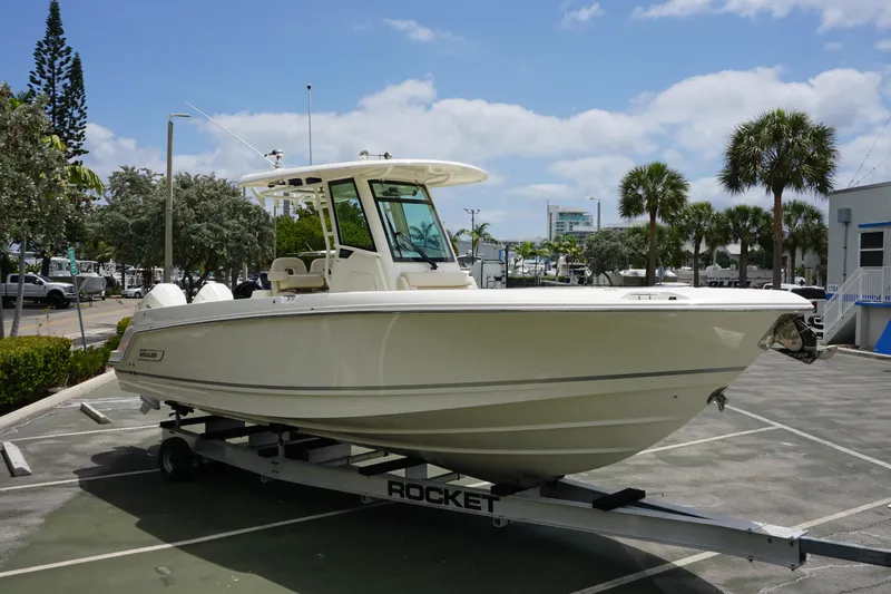 Slide: The Image of 2025 Boston Whaler 280 Outrage boat on trailer in sunny parking lot. - 5