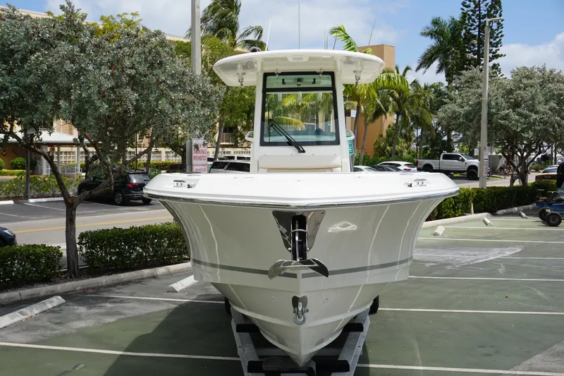 Slide: The Image of 2025 Boston Whaler 280 Outrage boat parked, front view, in a tropical setting. - 6