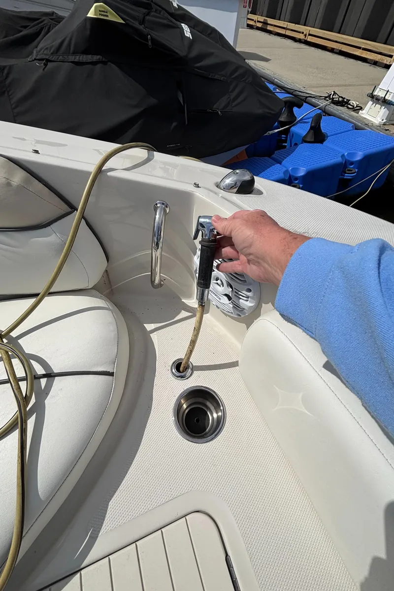 Slide: The Image of Person using a hose on a 2008 Sea Ray 290 Sundeck boat. - 25