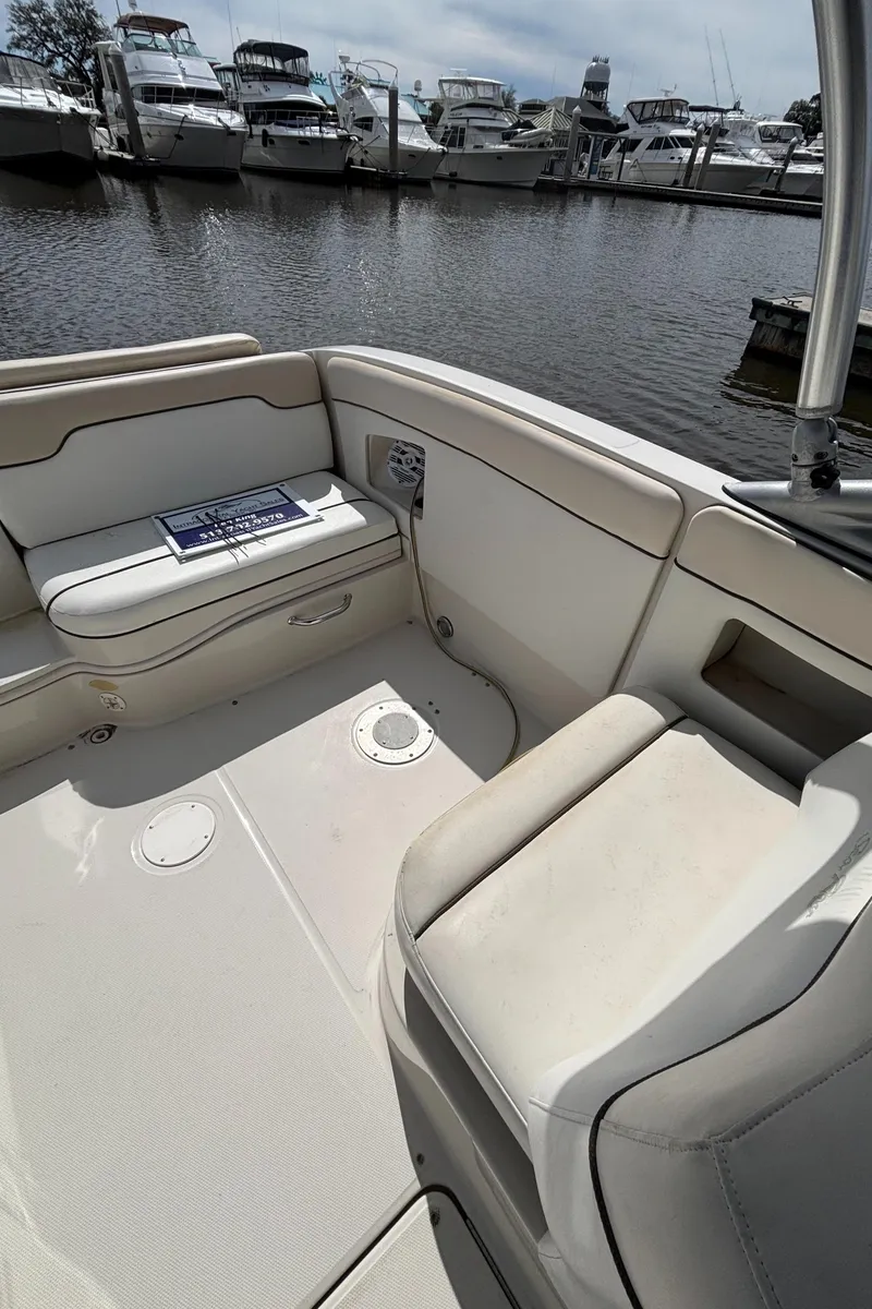 Slide: The Image of 2008 Sea Ray 290 Sundeck boat interior with white seating, docked at marina. - 33