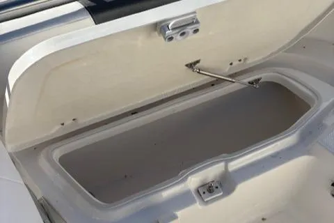 Slide: The Image of 2021 Robalo R200 Center Console storage compartment open, showcasing interior space. - 12
