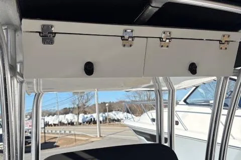 Slide: The Image of 2021 Robalo R200 Center Console storage compartment with secure latches, outdoor setting. - 5