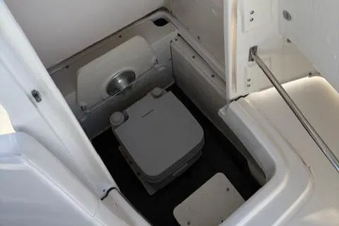 Slide: The Image of 2021 Robalo R200 Center Console boat interior with compact marine toilet. - 9