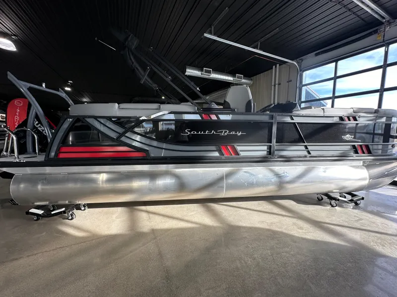 The Image of 2025 South Bay 523RS pontoon boat in showroom, featuring sleek design and modern accents. - 0