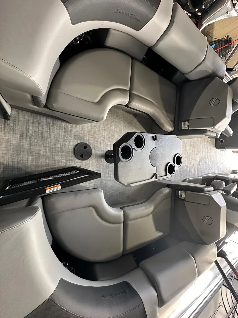 Slide: The Image of 2025 South Bay 523RS boat interior with gray seating and cup holders. - 3