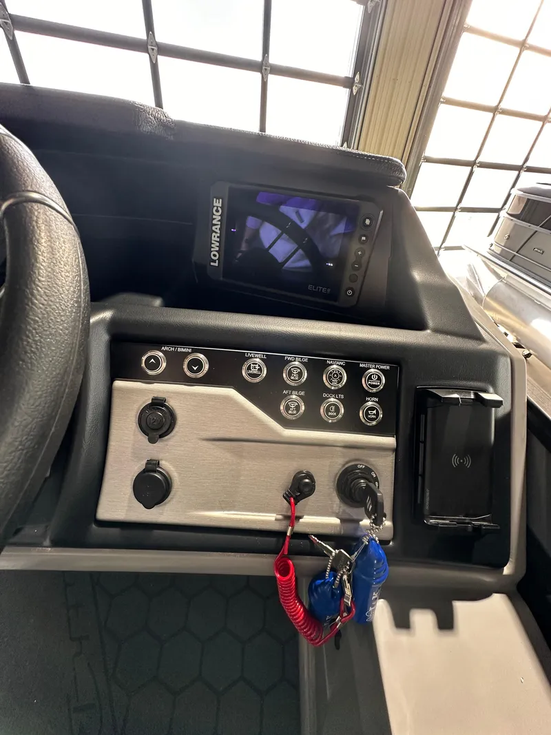 Slide: The Image of Control panel of 2025 South Bay 523RS boat with navigation screen and key fobs. - 9