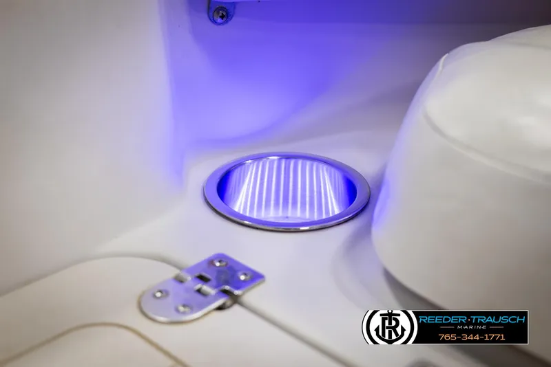 Slide: The Image of 2015 Starcraft 1915 Limited OB boat interior with blue LED lighting and metal hinge detail. - 37