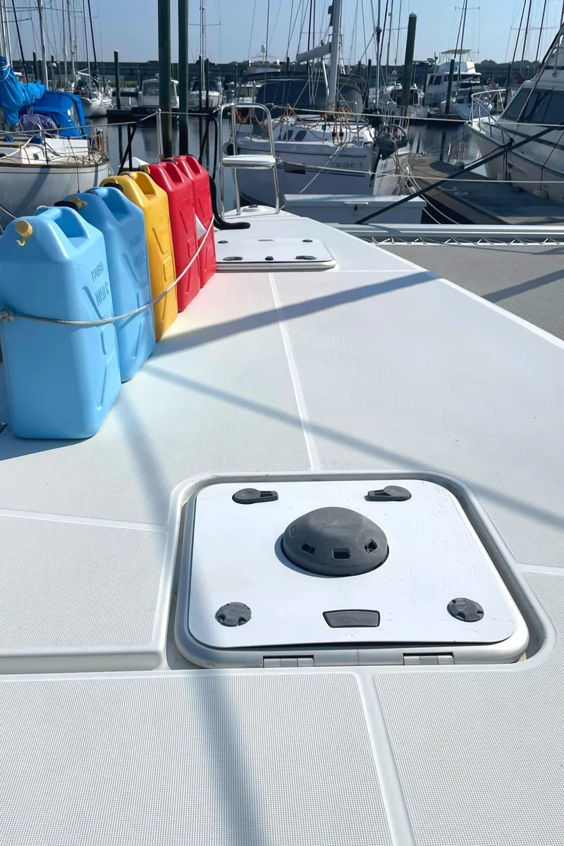 Slide: The Image of Deck of 2016 Lagoon 450 F catamaran with colorful fuel containers, docked at marina. - 14