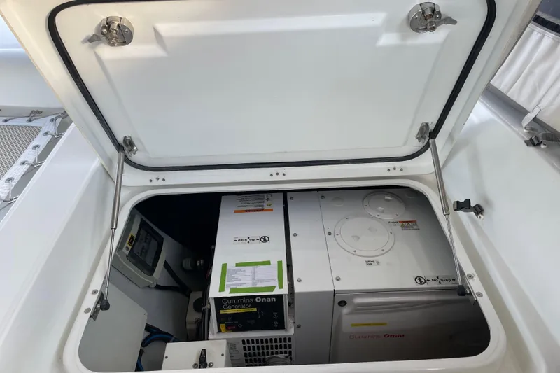 Slide: The Image of Open engine compartment of 2016 Lagoon 450 F catamaran, showcasing generator and equipment. - 20