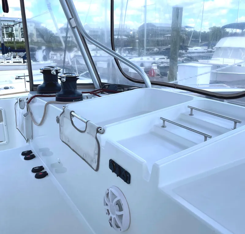 Slide: The Image of Cockpit view of 2016 Lagoon 450 F catamaran, featuring winches and marina background. - 26