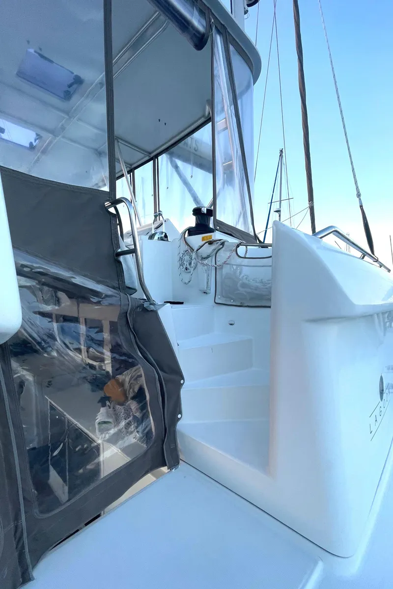 Slide: The Image of 2016 Lagoon 450 F catamaran with white exterior and clear enclosures. - 32