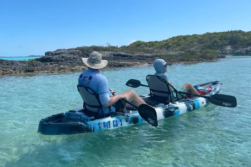 Slide: The Image of Two people kayaking in clear turquoise water near rocky shoreline. - 34