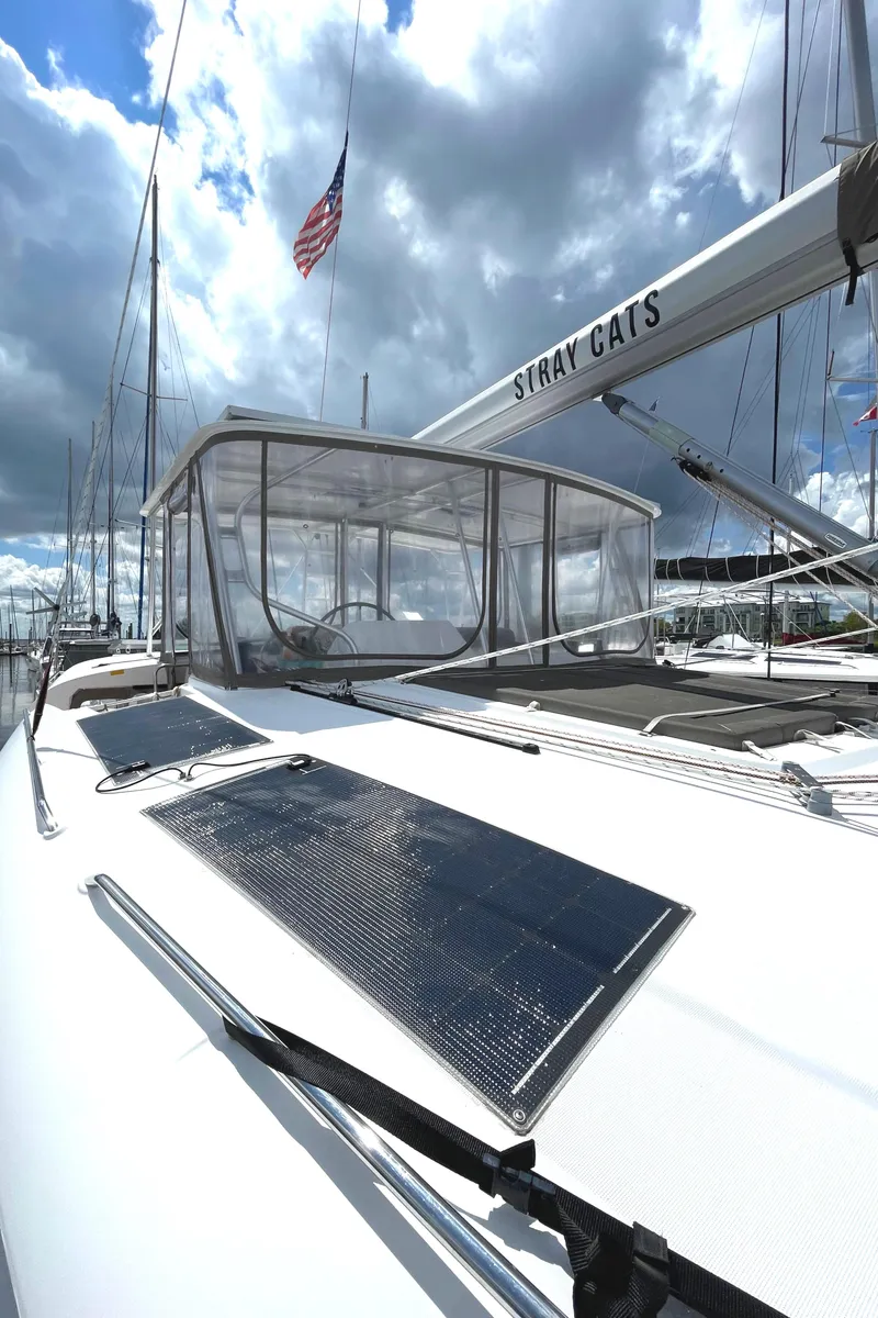 Slide: The Image of Lagoon 450 F catamaran, 2016 model, with solar panels and American flag, under cloudy sky. - 35