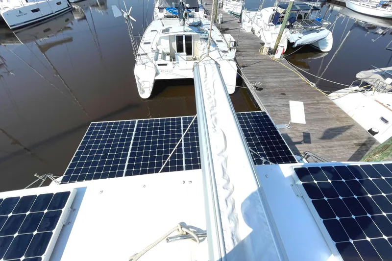 Slide: The Image of 2016 Lagoon 450 F catamaran with solar panels docked at a marina. - 37