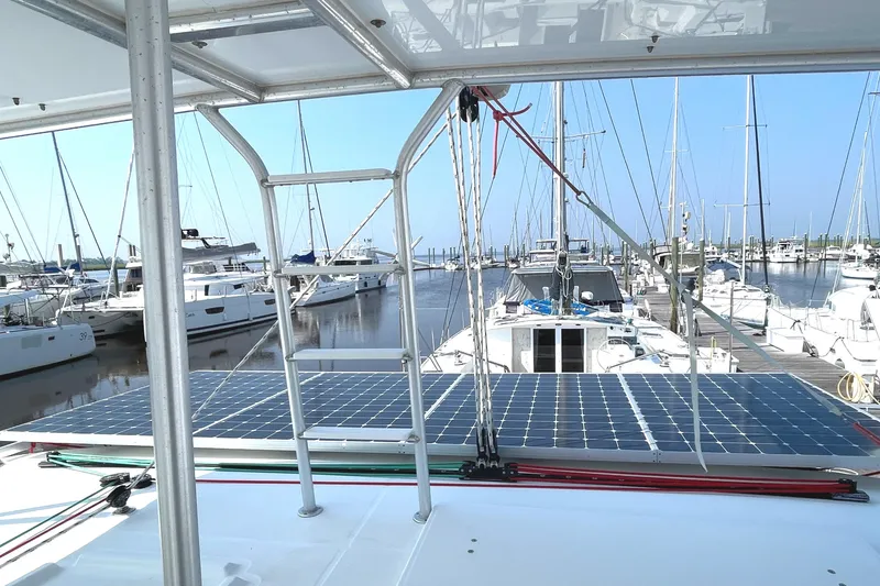 Slide: The Image of 2016 Lagoon 450 F catamaran with solar panels docked at a marina. - 39