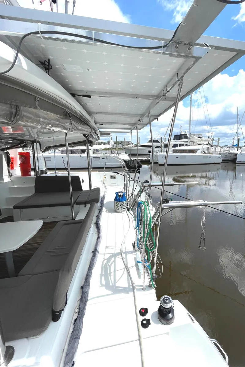Slide: The Image of 2016 Lagoon 450 F catamaran docked, featuring spacious deck and seating area. - 43