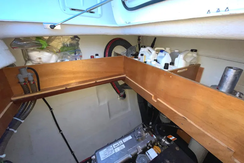 Slide: The Image of Engine compartment of a 2016 Lagoon 450 F catamaran with storage shelves and maintenance supplies. - 47