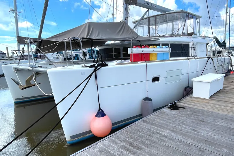 Slide: The Image of 2016 Lagoon 450 F catamaran docked at marina with colorful storage boxes on deck. - 6