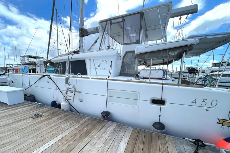 Slide: The Image of 2016 Lagoon 450 F catamaran docked at marina under blue sky. - 7