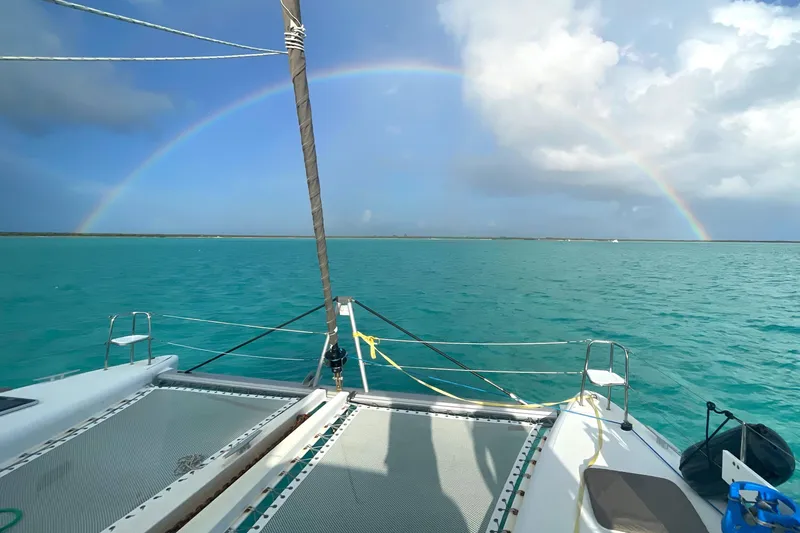 Slide: The Image of Catamaran Lagoon 450 F sailing under a vibrant rainbow on turquoise waters, 2016 model. - 8