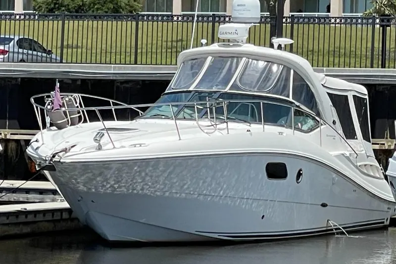 Slide: The Image of 2010 Sea Ray 350 Sundancer docked at marina, sleek white design. - 12